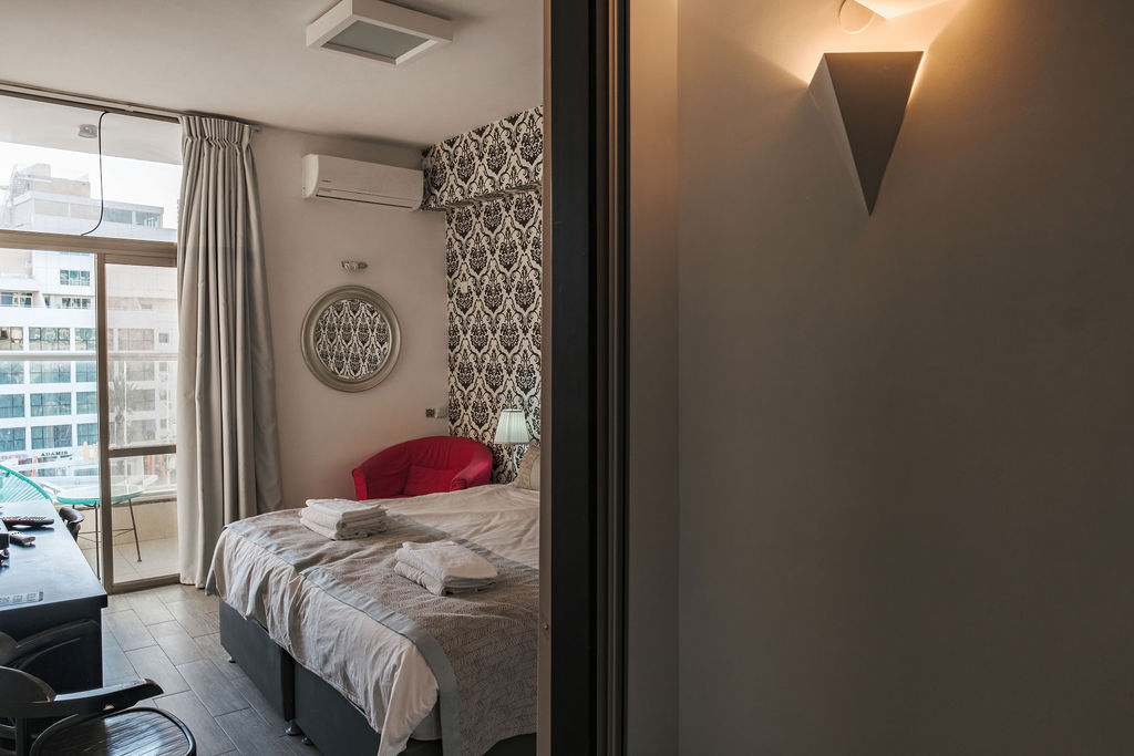 Chambre avec papier peint baroque et vue sur Netanya à l'Hotel Kikar