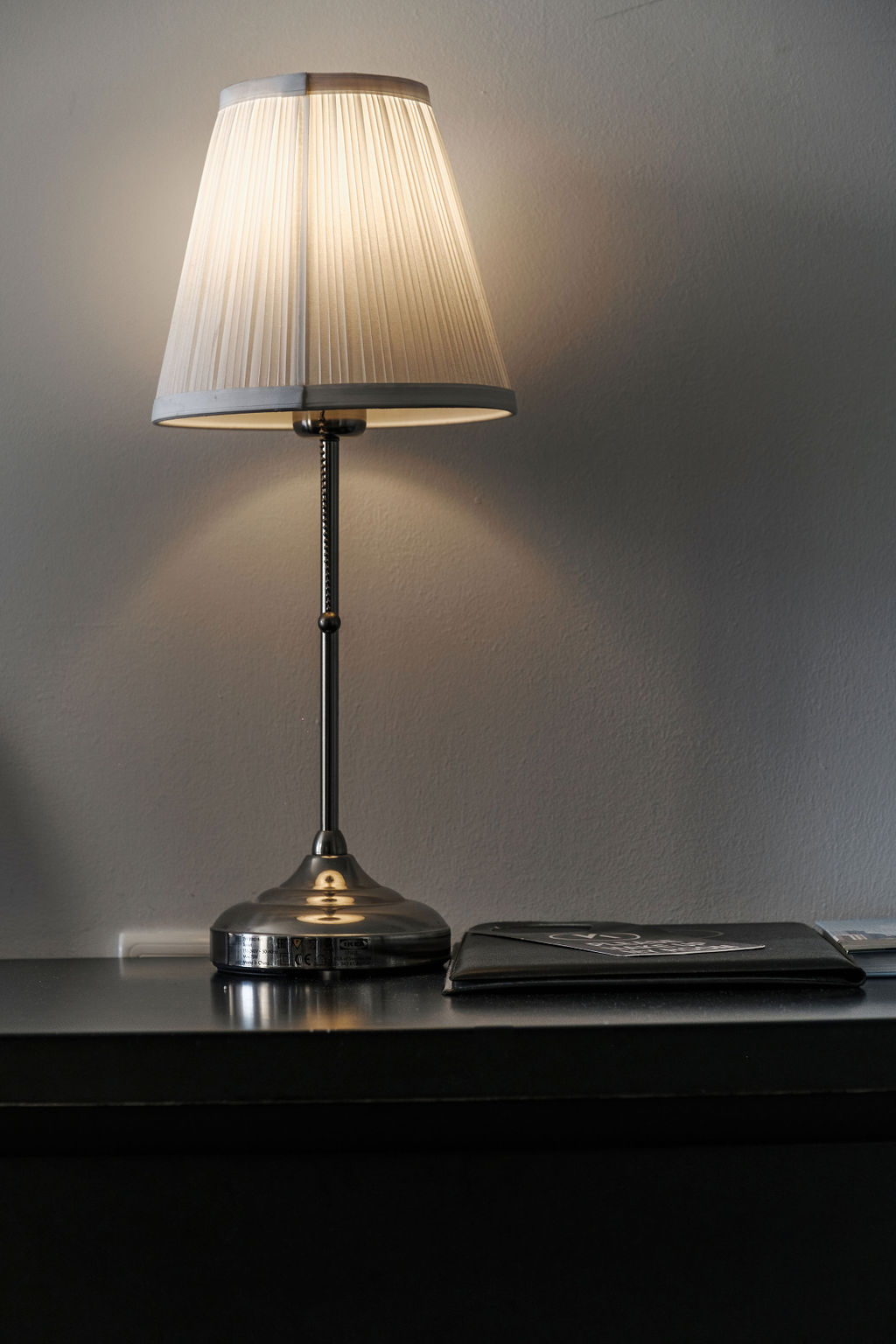 Lampe de chevet allumée diffusant une lumière chaleureuse à l'Hotel Kikar Netanya