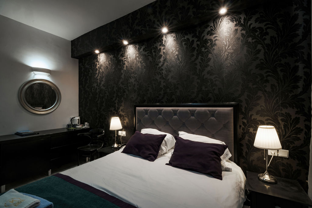 Chambre intimiste à tête de lit capitonnée et papier peint damassé à l'Hotel Kikar Netanya
