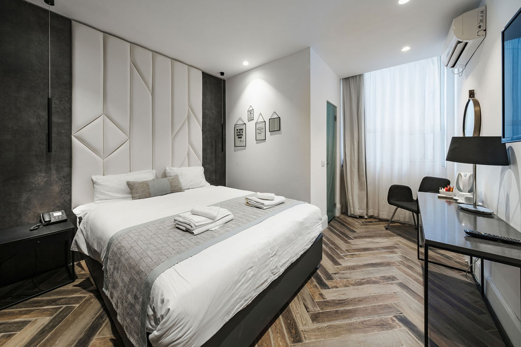 Chambre King avec parquet chevron et bureau à l'Hotel Kikar Netanya