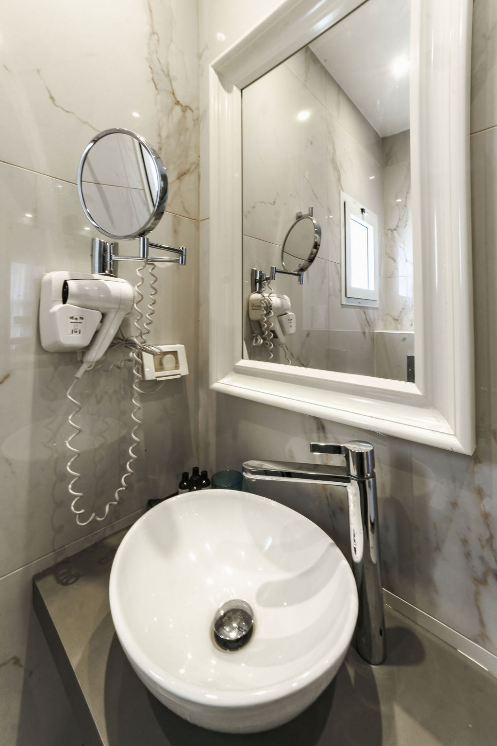 Coin vasque et sèche-cheveux dans la salle de bain de l'Hotel Kikar Netanya