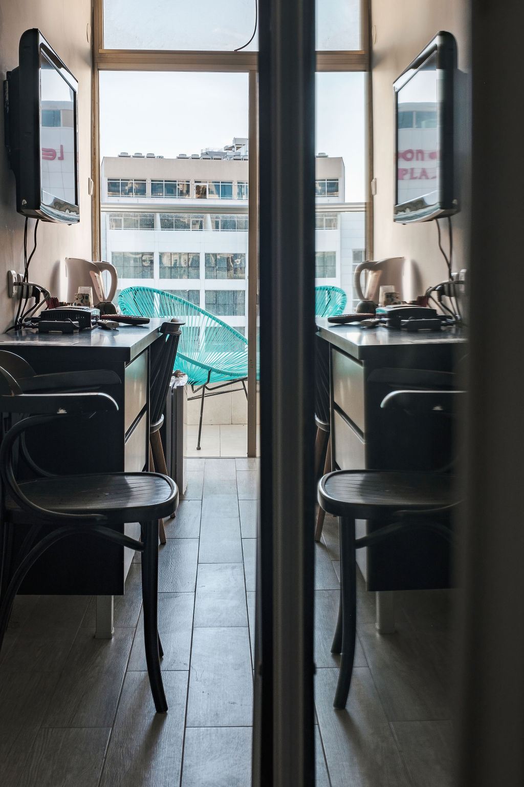 Vue depuis l'entrée vers le balcon et les fauteuils turquoise