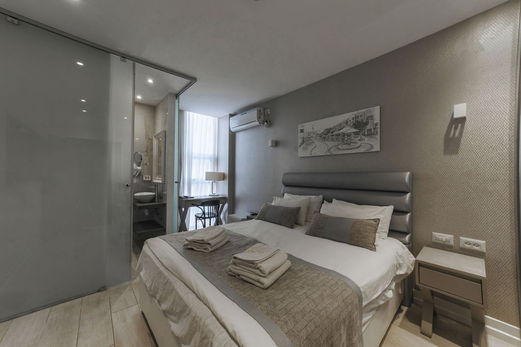 Chambre King avec porte coulissante en verre vers la salle de bain