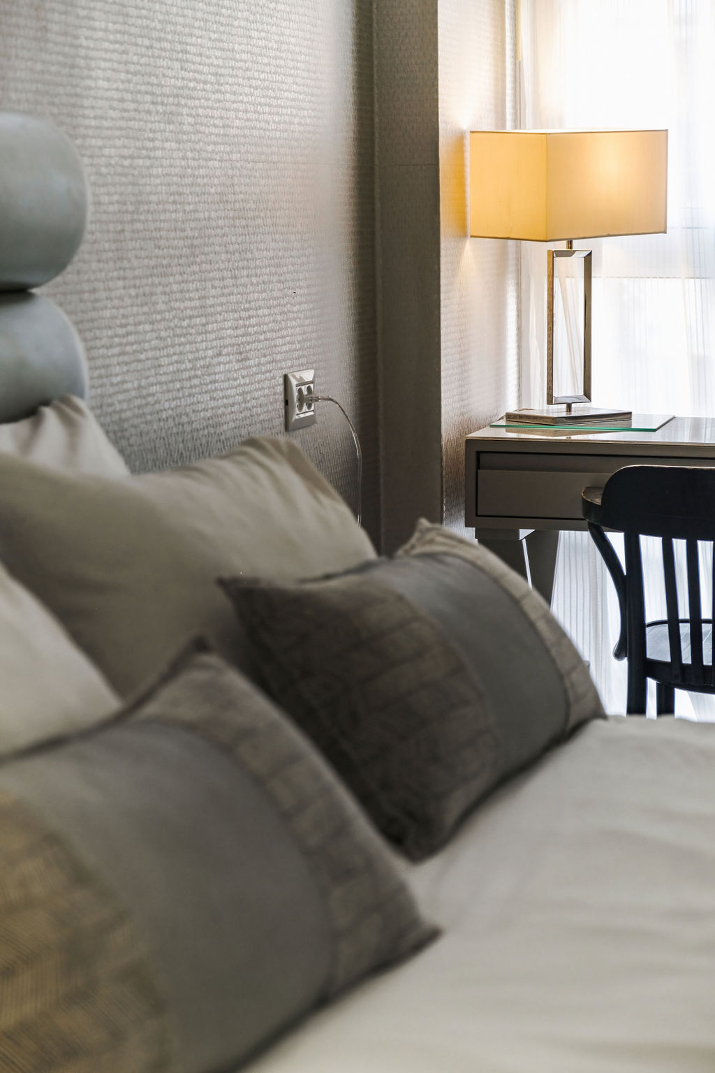 Lit garni de coussins avec bureau et lampe à l'Hotel Kikar Netanya