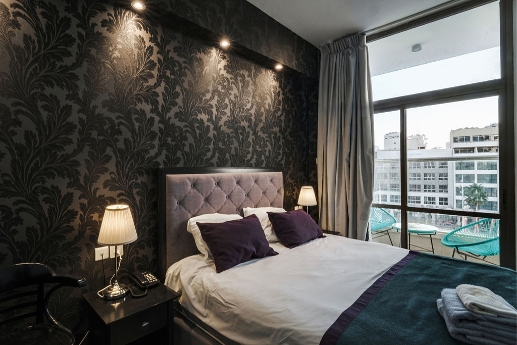 Chambre signature avec balcon et fauteuils turquoise à l'Hotel Kikar Netanya