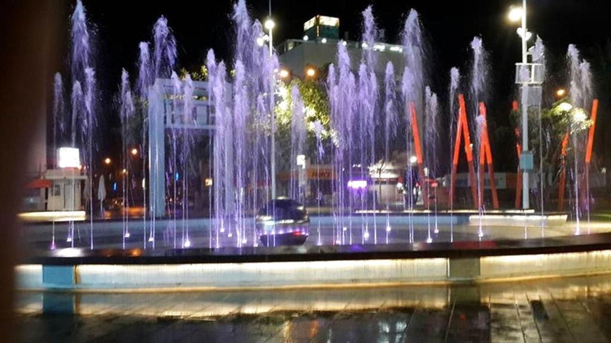 Fontaines lumineuses violettes de la place la nuit
