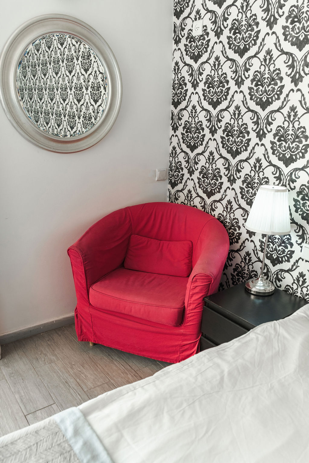 Coin lecture avec fauteuil rouge et miroir argenté à l'Hotel Kikar Netanya