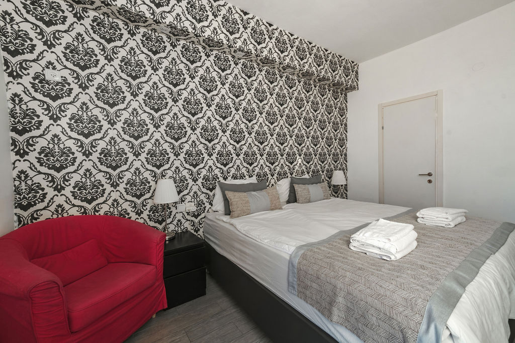Chambre Twin damassée avec canapé rouge à l'Hotel Kikar Netanya